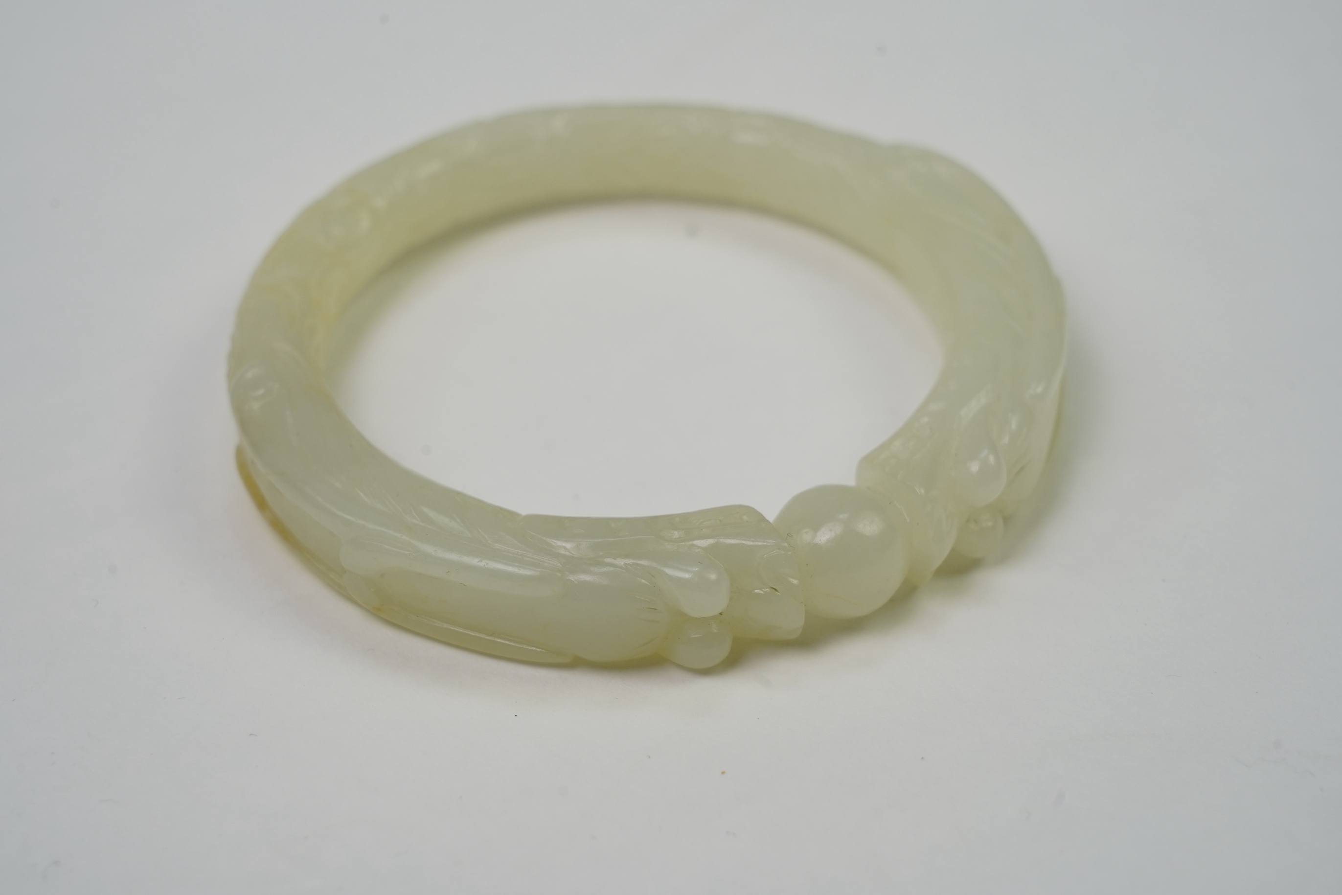 A Chinese pale celadon jade ’dragon’ bangle